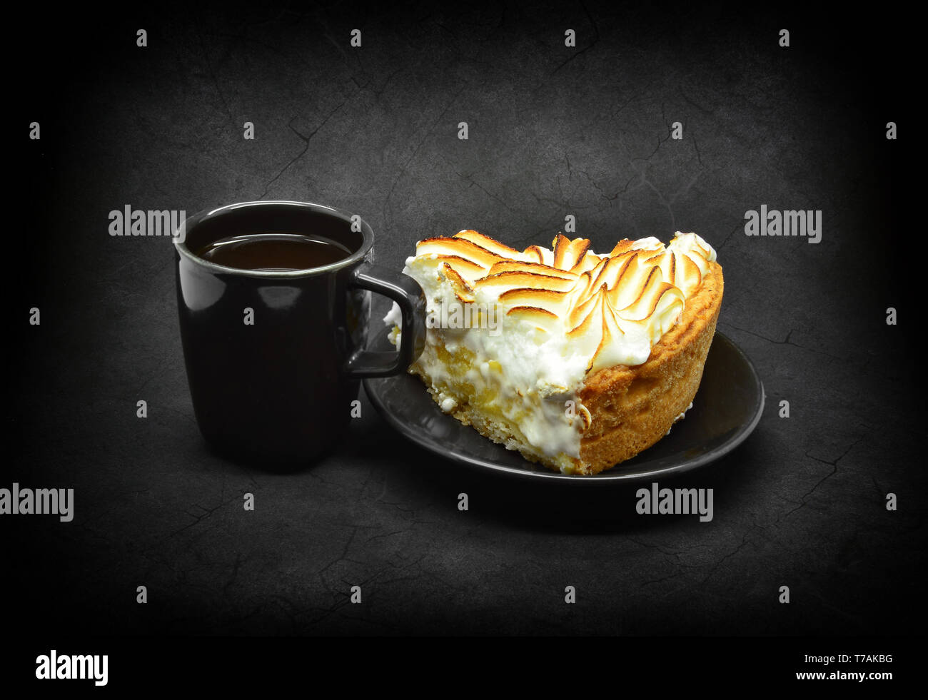 Small black cup of coffee and piece and a piece of meringue cake. Stock Photo