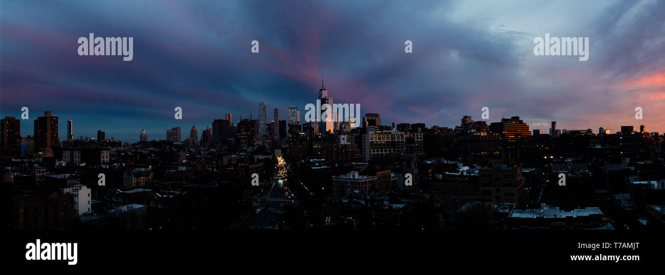 A panoramic view of the afterglow of a sunset above lower Manhattan, New York City, with the World Trade Center (Freedom Tower) visible. Stock Photo