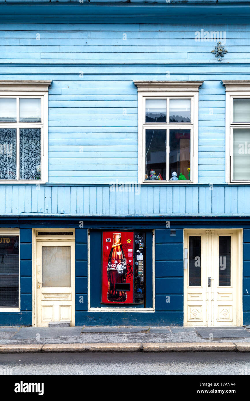 Blue facade of typical wooden Norwegian house with a disused coca-cola vending machine, Bergen, Norway Stock Photo