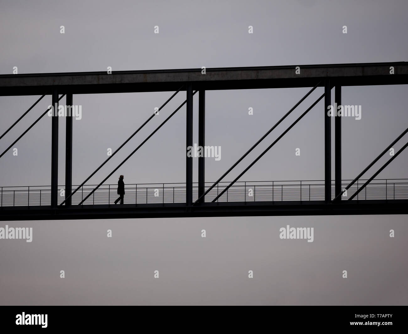 The Silhouette of A Woman Walking On A Bridge Stock Photo - Alamy