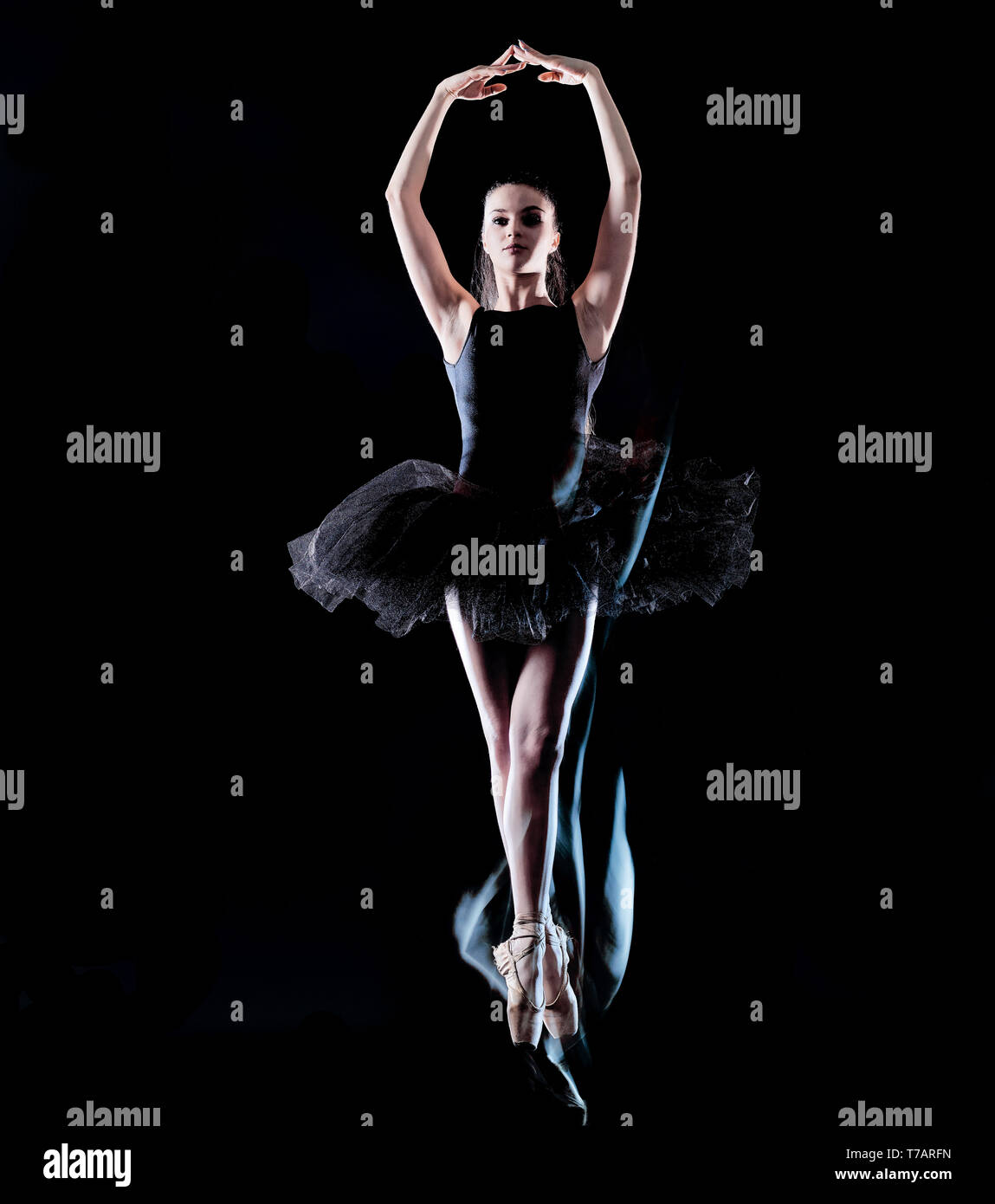 one caucasian young woman ballerina dancer dancing isolated on black background with  light painting motion blur speed effect Stock Photo