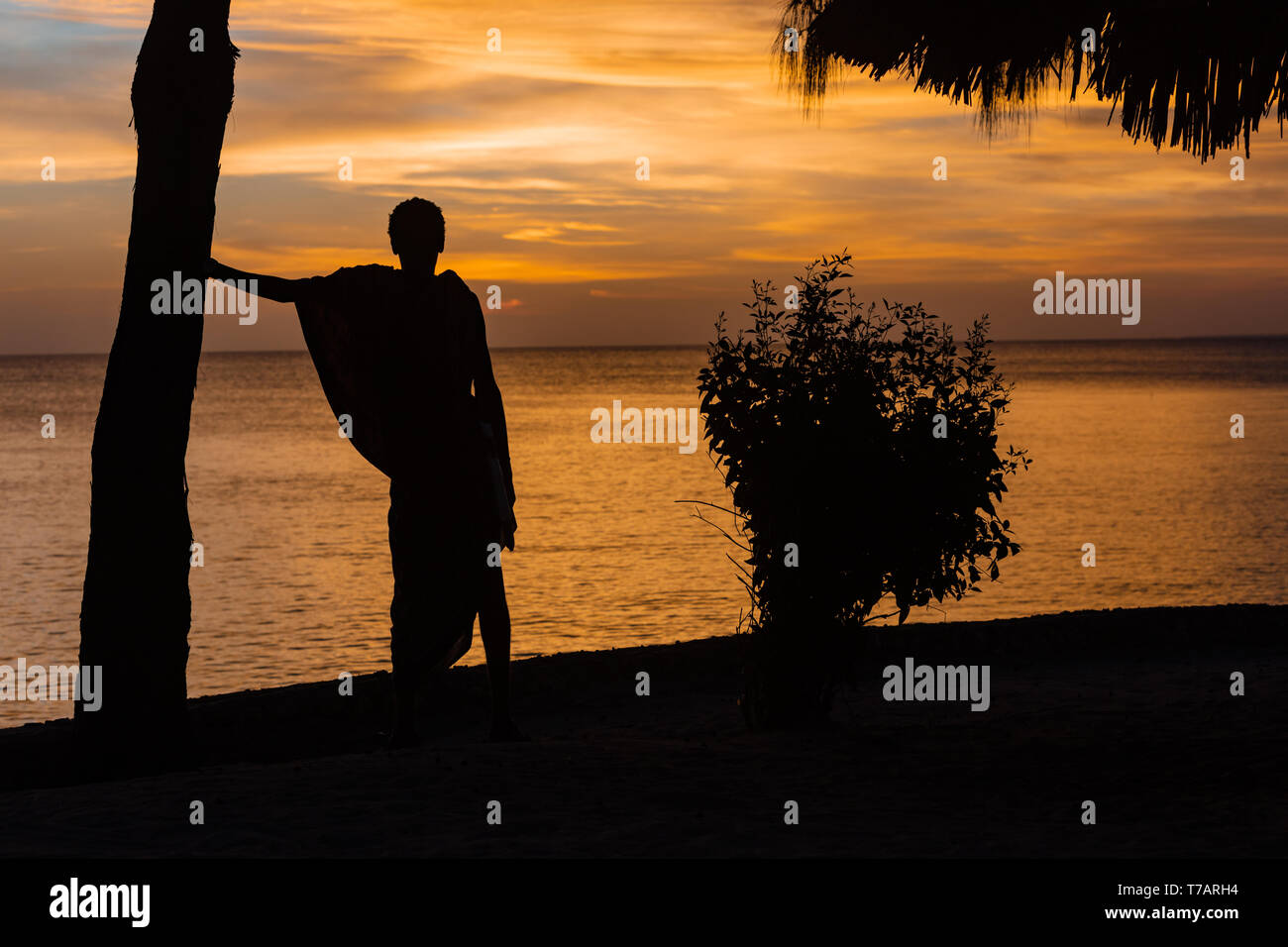 Masai man looking at sunset over the sea at Kizimkazi in Unguja aka Zanzibar Island Tanzania East Africa Stock Photo