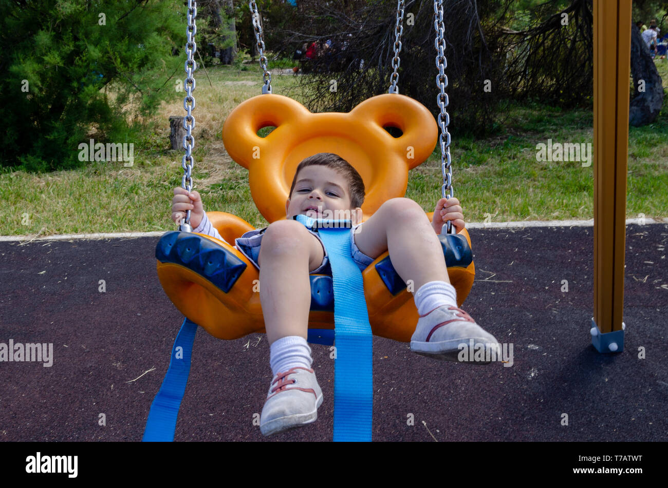 Cute two years old boy playig in the children playground outdoors on