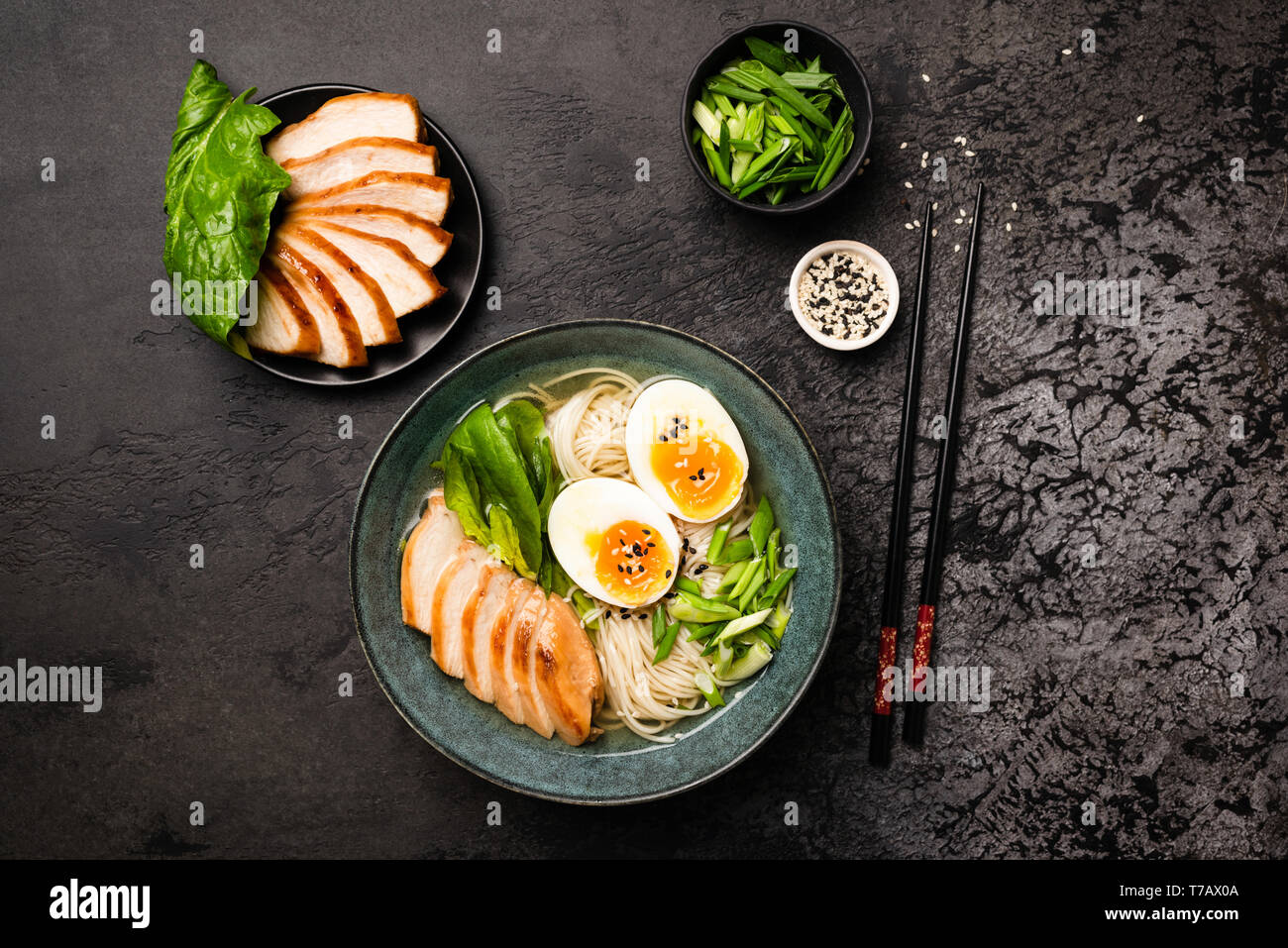 Asian Chicken Ramen Noodle Soup On Black Concrete Background. Table Top View Stock Photo