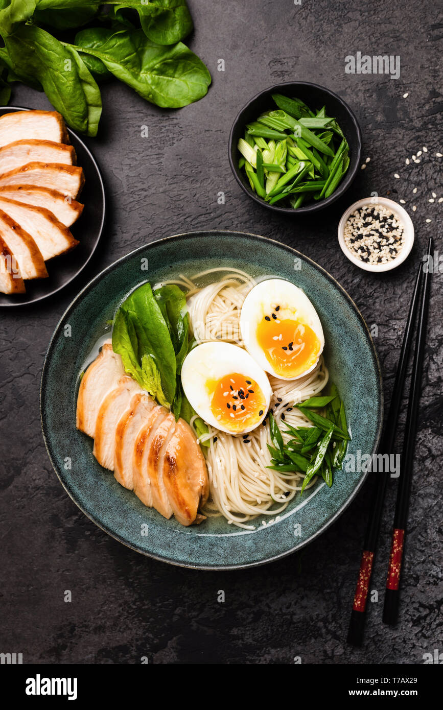 Chicken Ramen Soup In Bowl With Egg. Table Top View. Black Concrete Background. Asian Cuisine Stock Photo