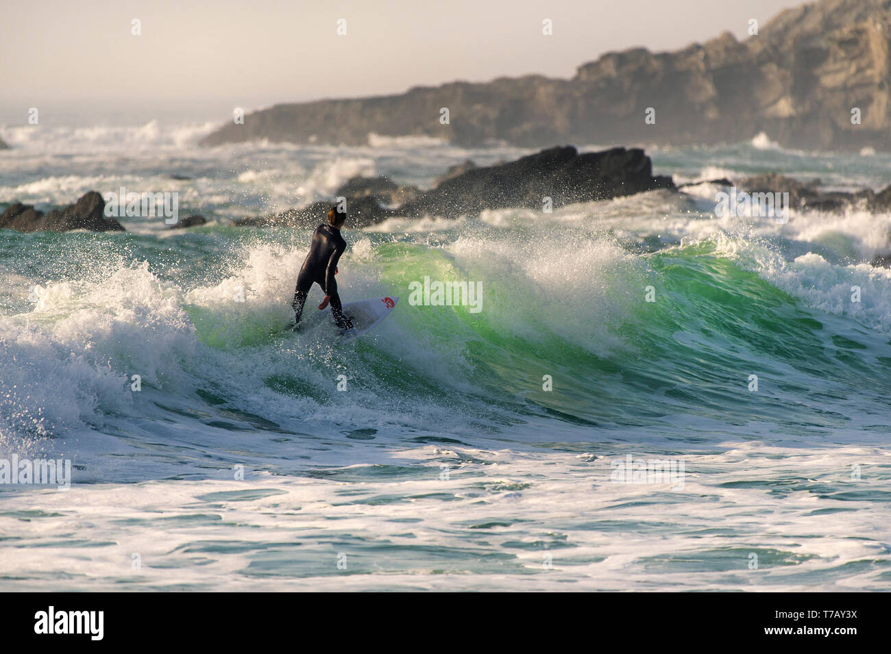 A surfer carving a wave at popular surfing hotspot Fistral beach in Newquay in Cornwall. Stock Photo