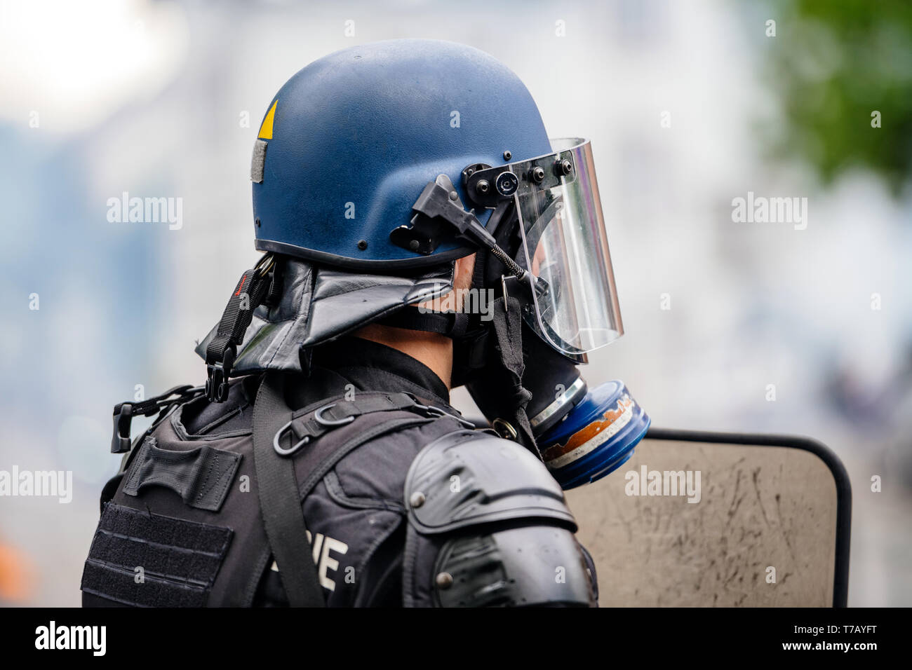 Rear view of police officer wearing gas mask against tear gas at ...