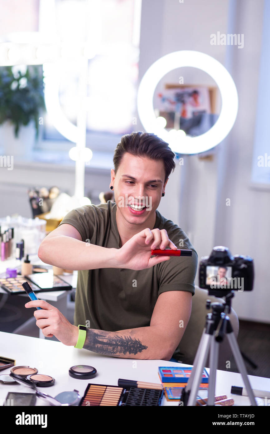 Smiling good-looking young guy presenting new products on camera Stock Photo