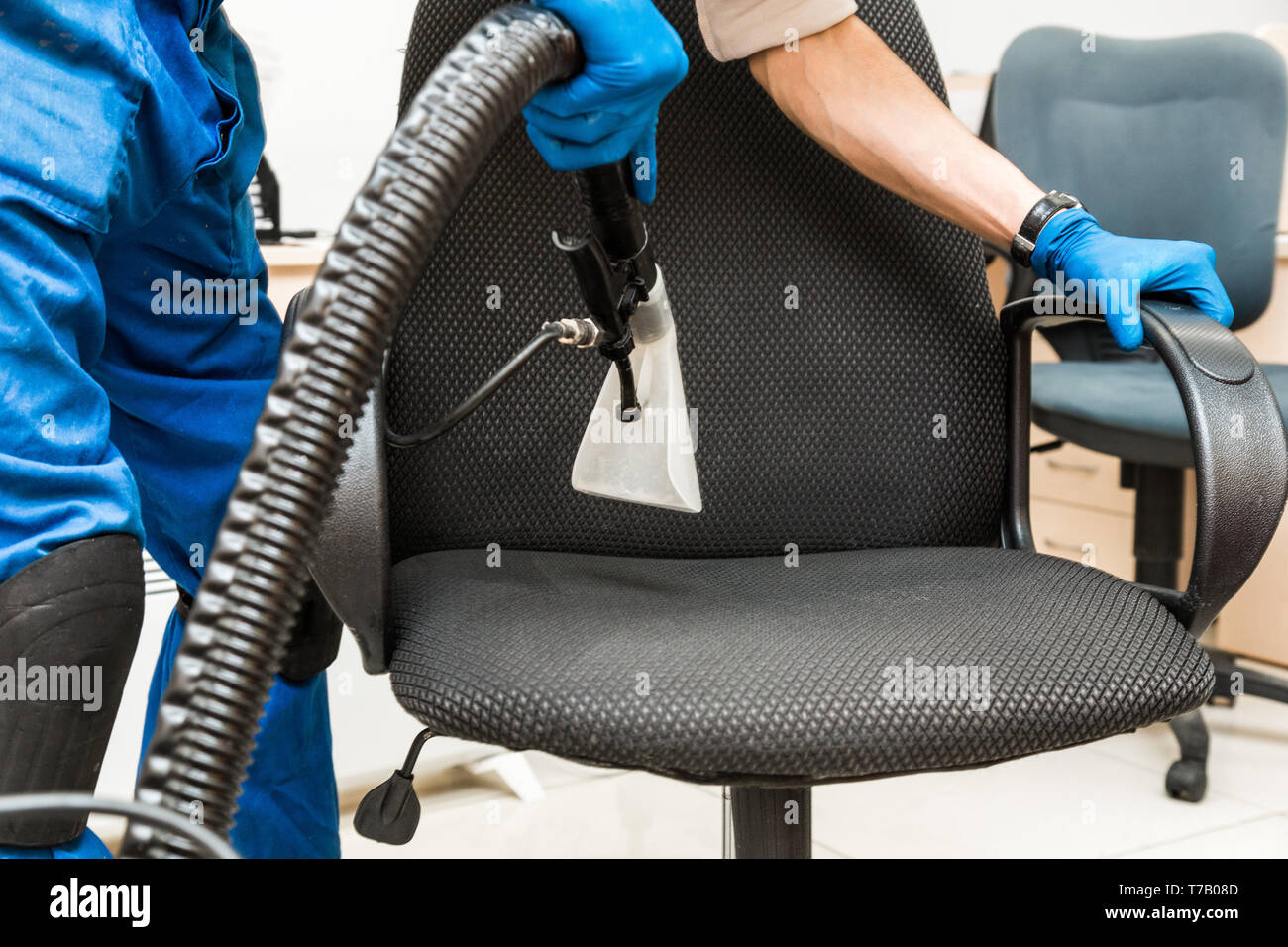Cleaning service. Young man in workwear and rubber gloves cleans the ...