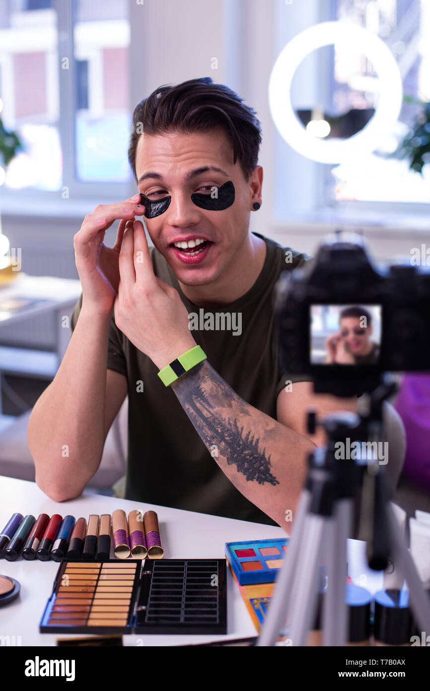 Laughing accurate guy enjoying new black patches for eyes Stock Photo