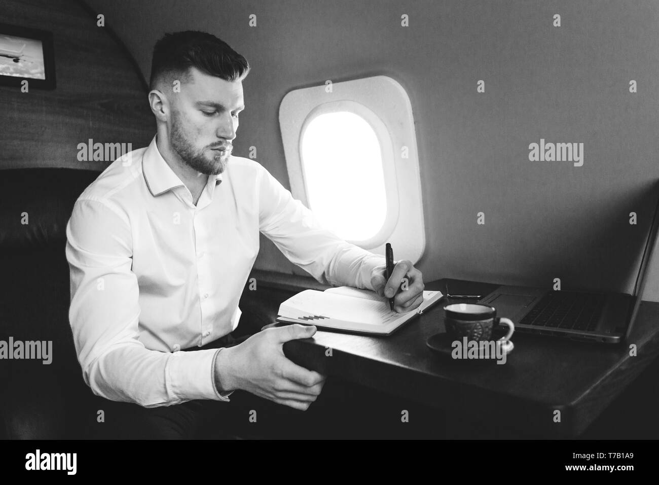 attractive and successful businessman in a white shirtt working sitting in the chair of his