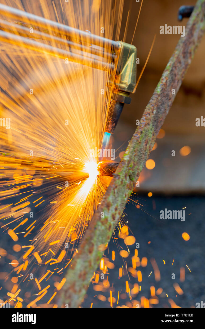 Cutting through wrought iron with a gas torch Stock Photo