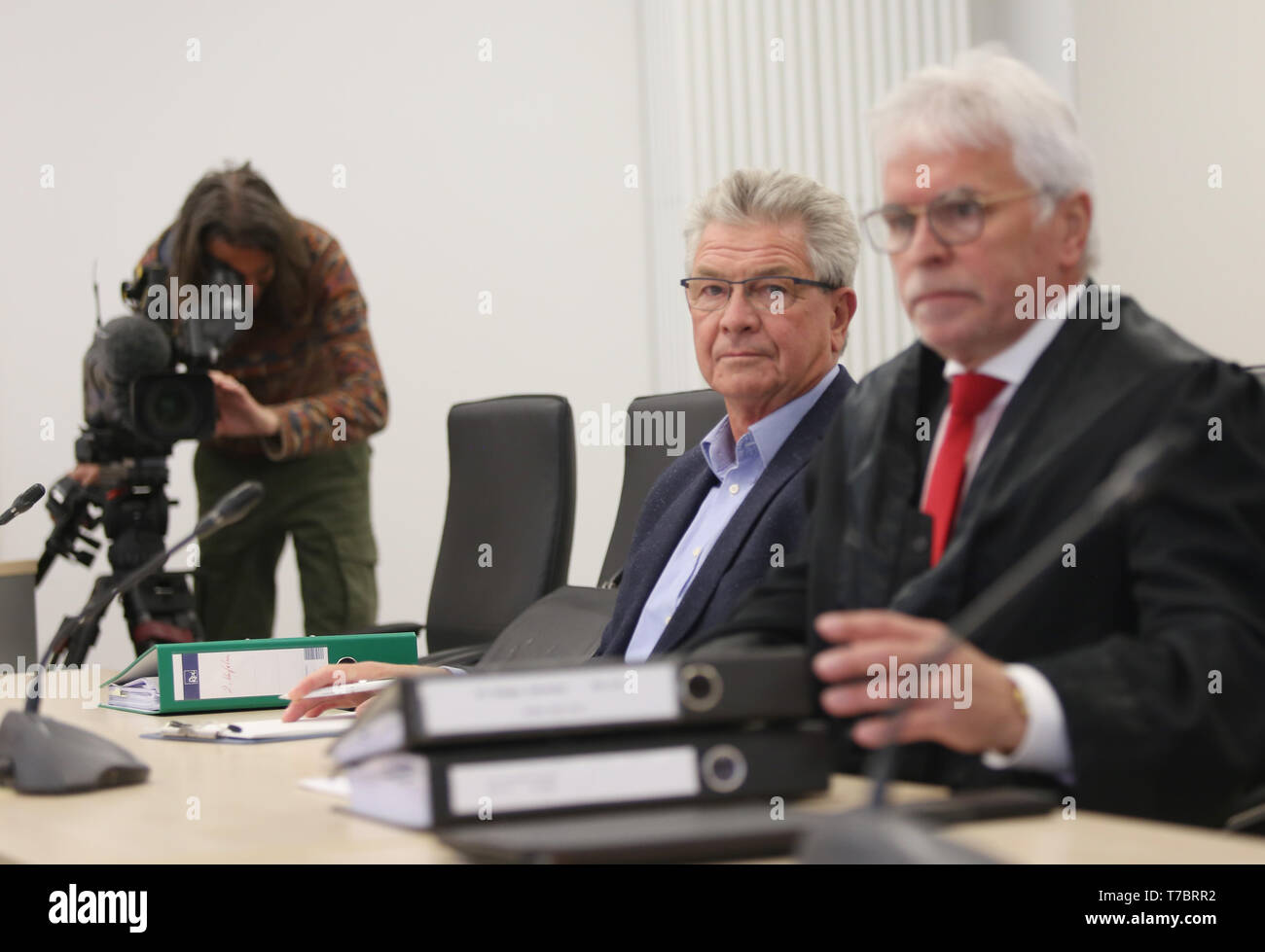 03 May 2019, Mecklenburg-Western Pomerania, Rostock: At the beginning of the trial against Dr. Amandus Krüger (M), the former Managing Director of the People's Solidarity Societies for fraud and delay in insolvency, the defendant sits in the courtroom next to his lawyer Dietmar Rudloff (R). The public prosecutor's office accuses the 68-year-old of being the managing director of Volkssolidarität Sozial-Immobilienfond GmbH & Co. KG (VSI KG) in the period between July 2004 and October 2005 in 144 legally related cases. The man had been sentenced to three years and eight months imprisonment by the Stock Photo