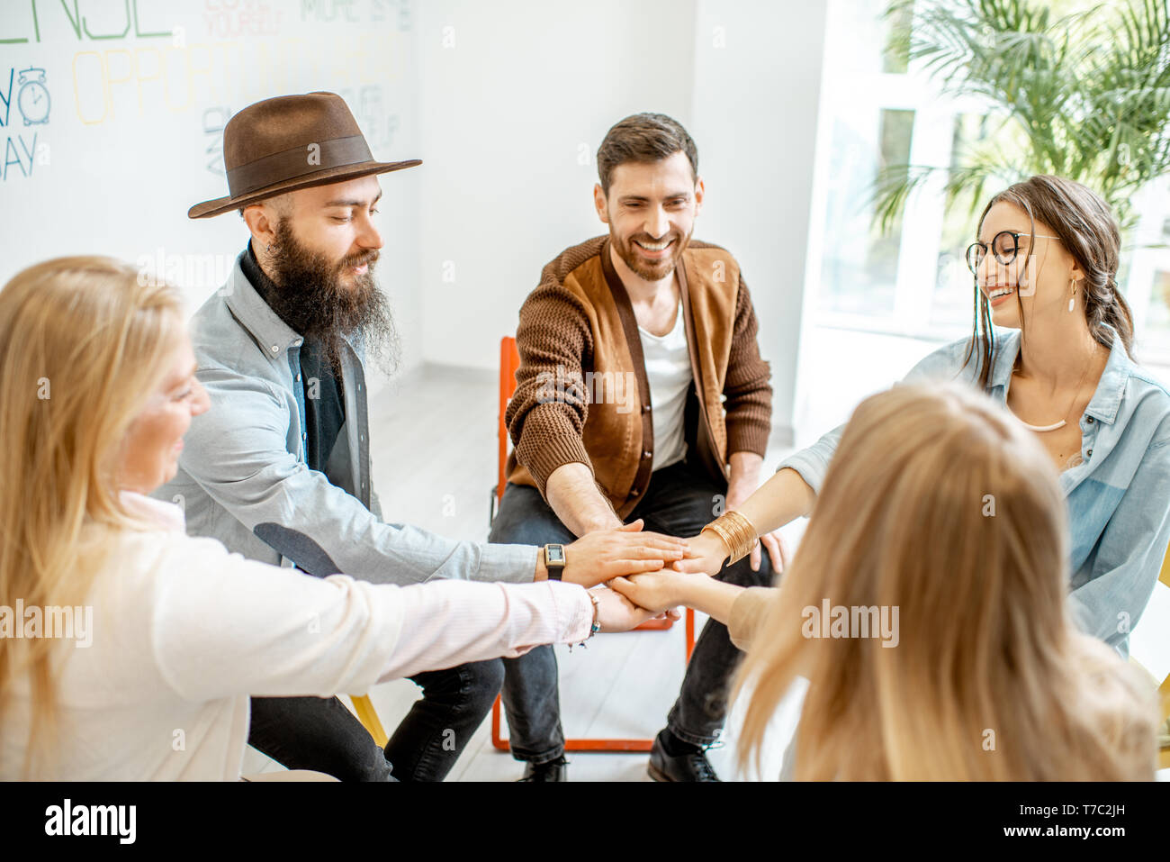 Group of diverse people keeping hands together, sitting in a circle during  the psychological therapy, feeling support from each other Stock Photo -  Alamy