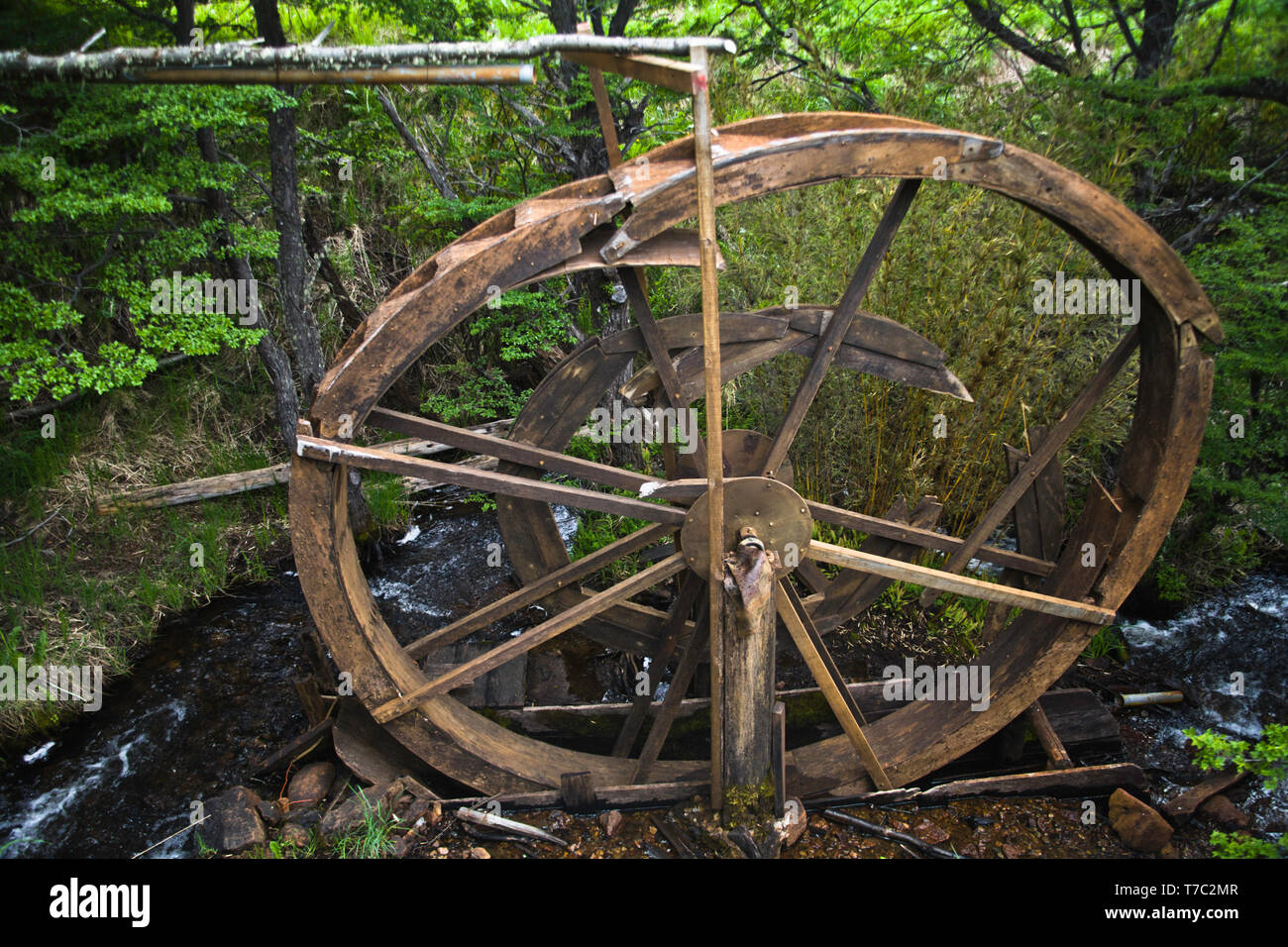 A disused broken traditional ,carved, wooden, overshot water wheel  used to generate power for forestry tools in Patagonia. Stock Photo