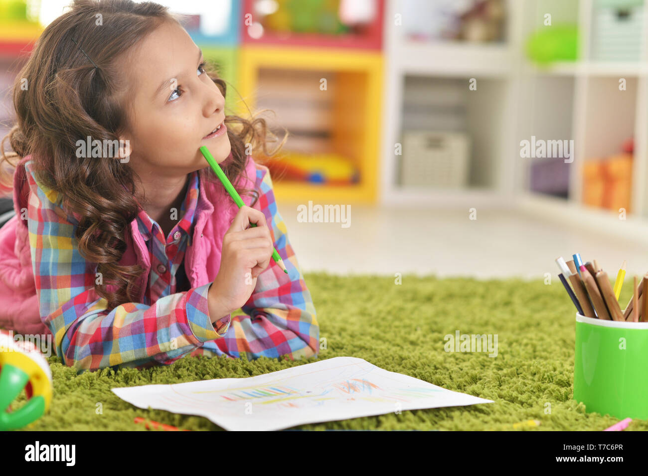 Portrait of cute girl lying on floor and drawing Stock Photo - Alamy