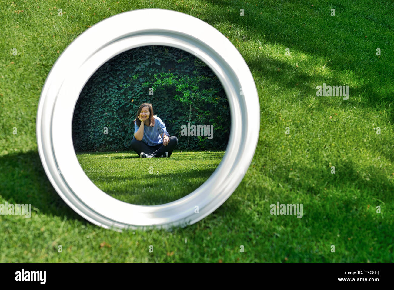 Girl looking in mirror with nature background Stock Photo