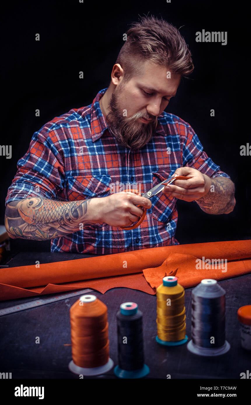 Professional Leather Worker forms new leather product at his workshelf Stock Photo