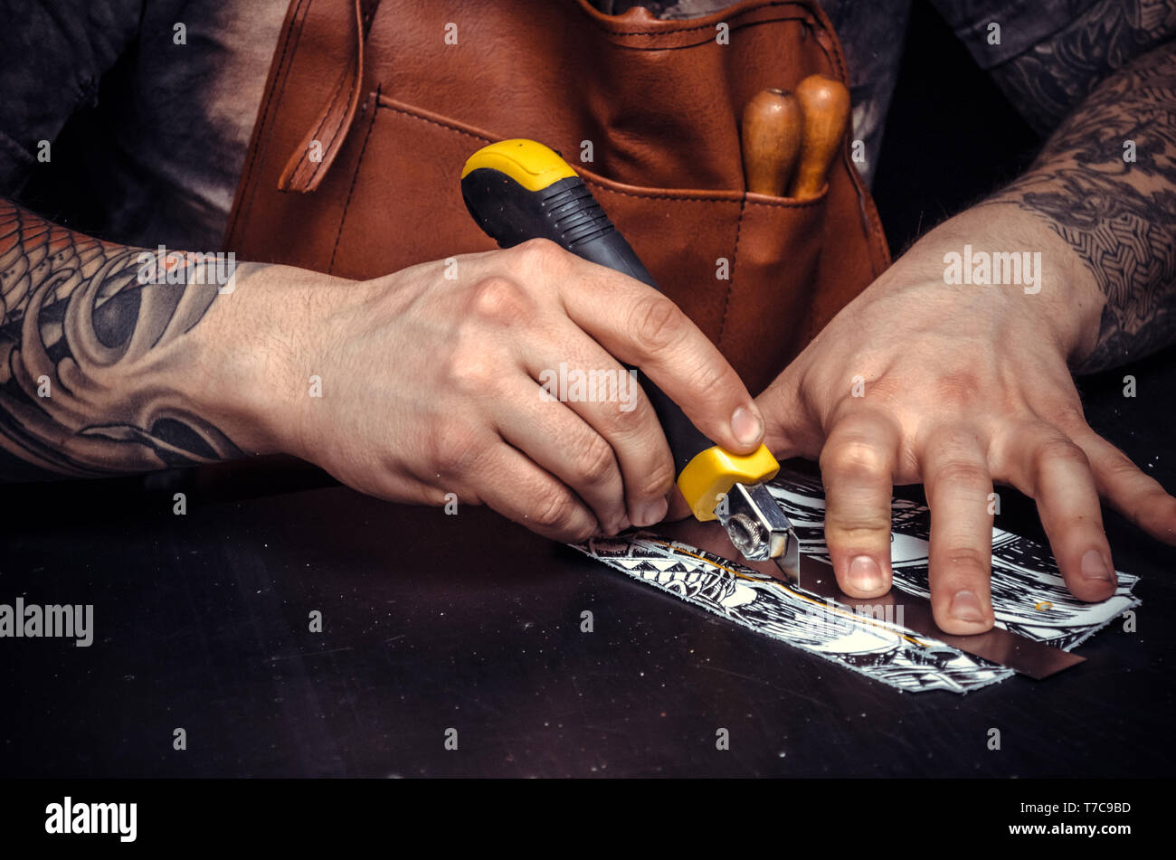 Leather Worker cutting out leather goods in a workshop Stock Photo