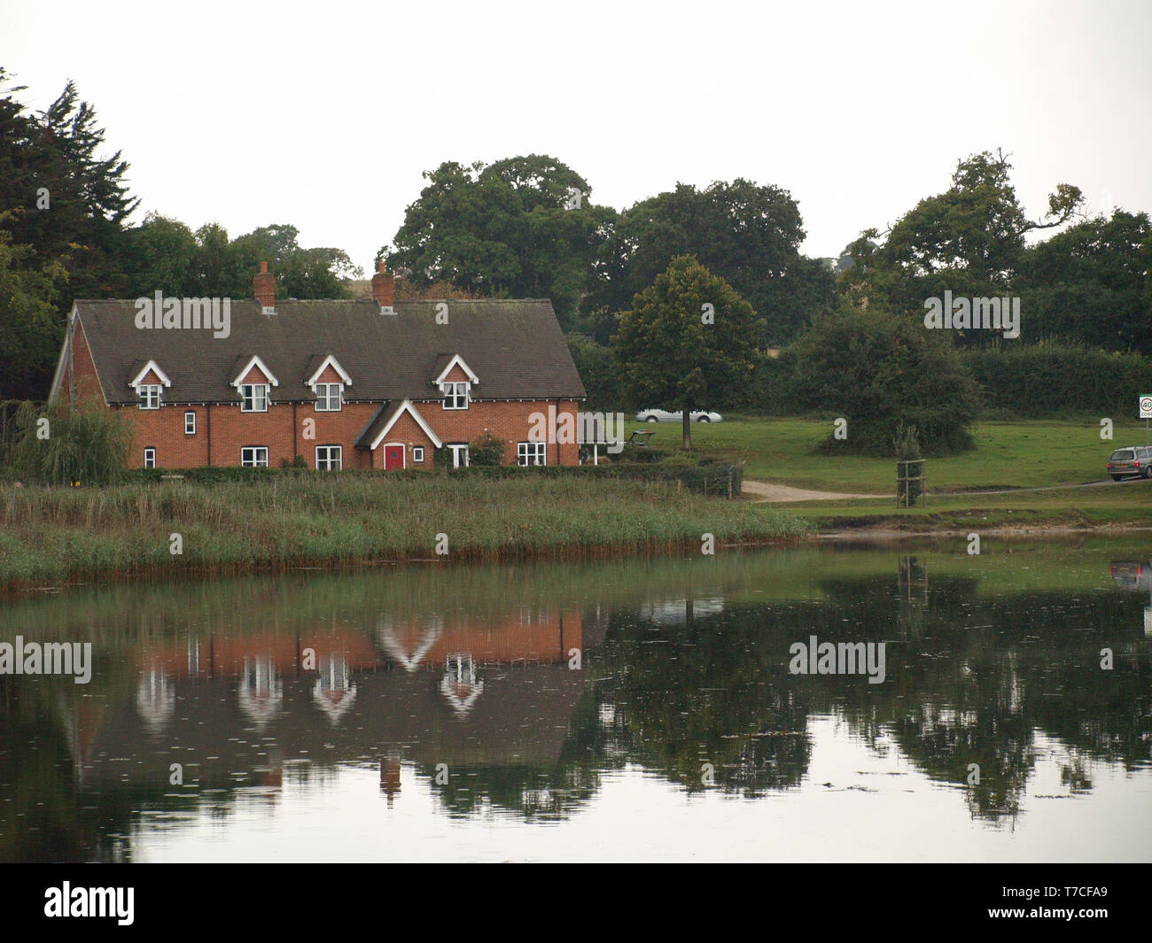 Country cottage reflected in Beaulieu River at Beaulieu, New Forest