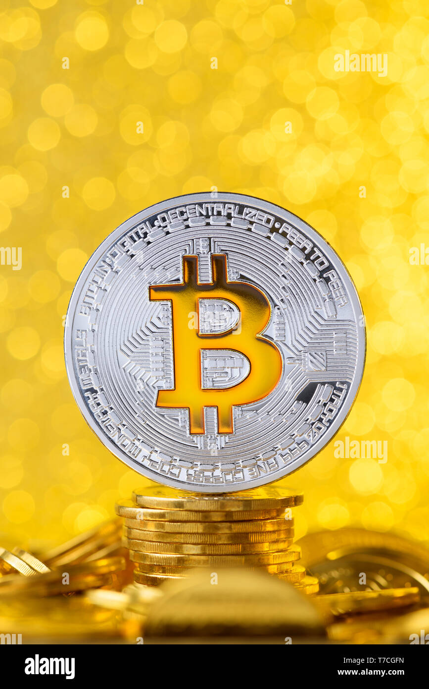 Bitcoin with bit symbol on top of gold coin stack with shiny golden background Stock Photo