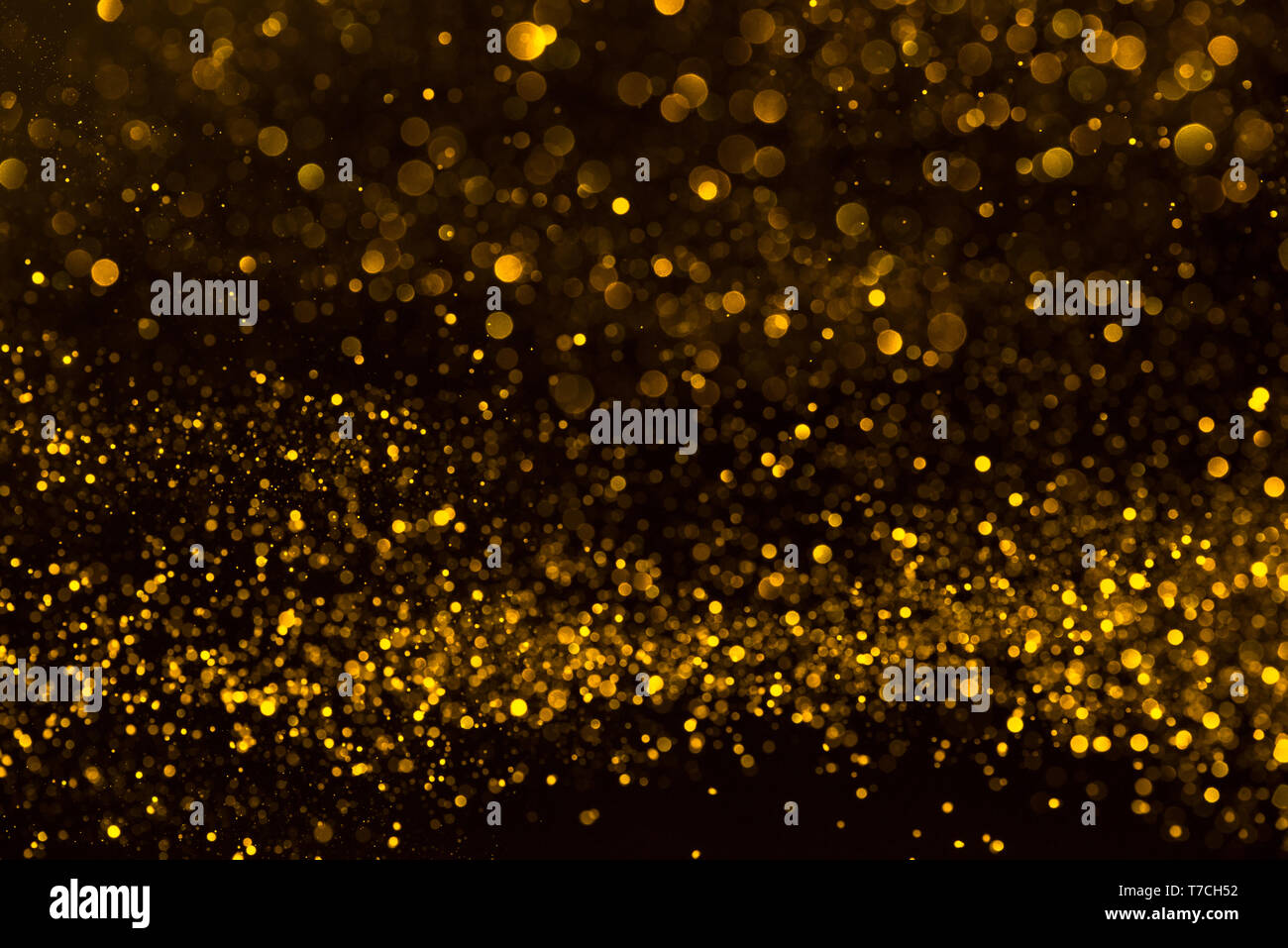 Sparkling golden confetti flow abstract background Stock Photo