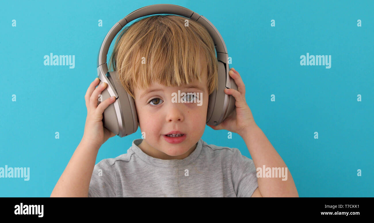 Baby takes off his headphones Stock Photo