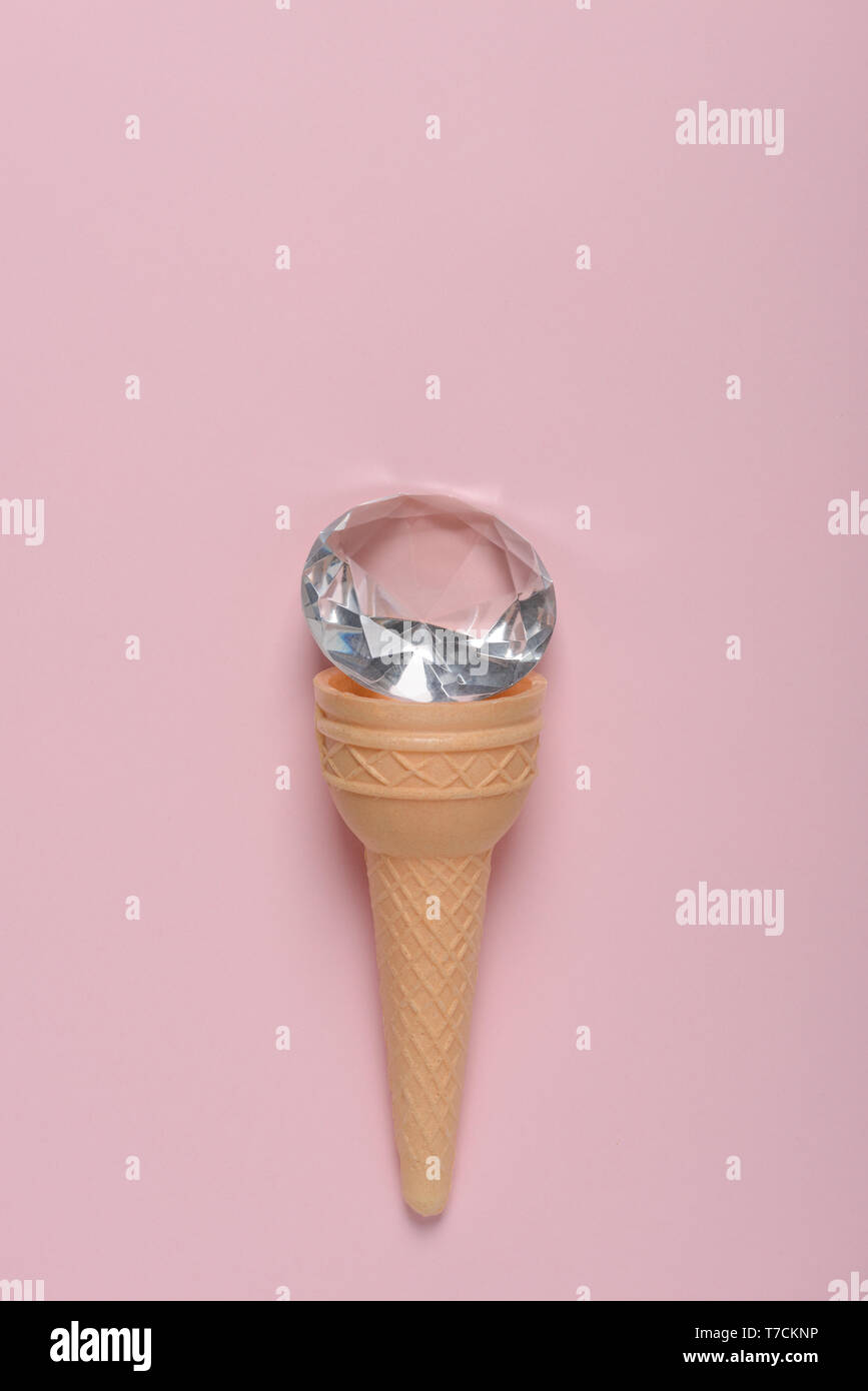 Ice cream waffle cone with shiny jewel on pink pastel background flat