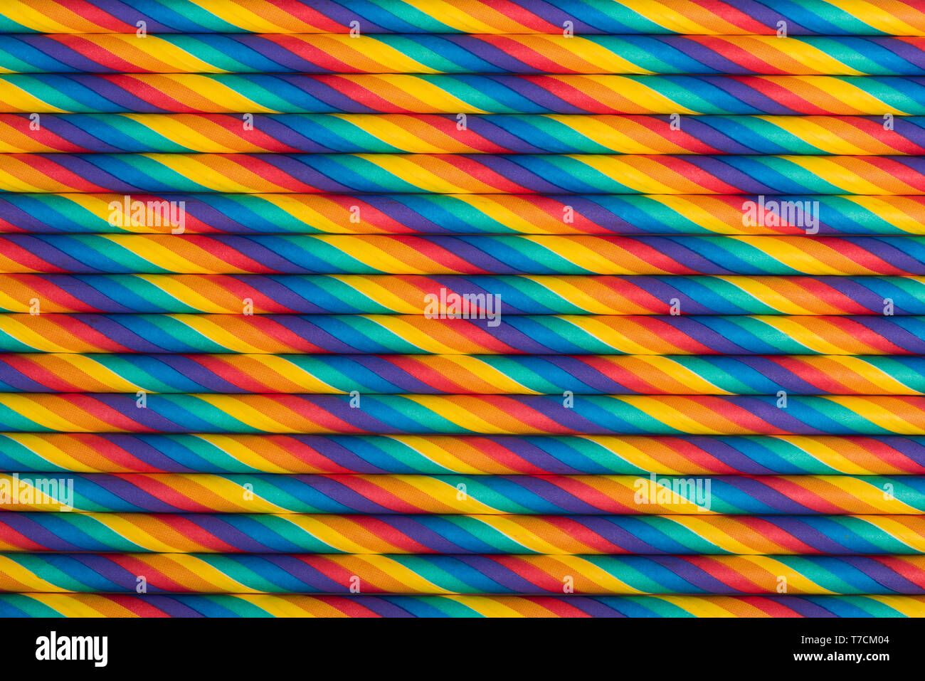 Rainbow vibrant multicolored striped paper straws background Stock Photo