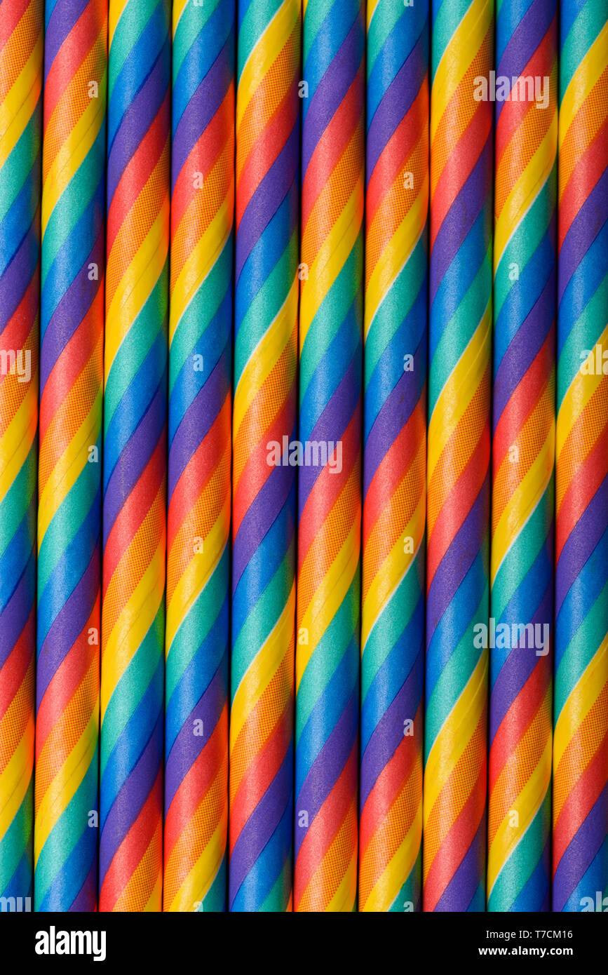 Rainbow multicolored striped paper straws vertical background Stock Photo
