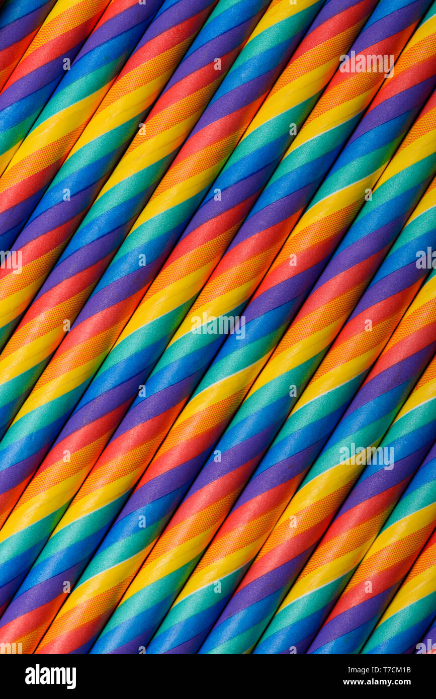 Rainbow vibrant multicolored striped paper straws vertical background Stock Photo