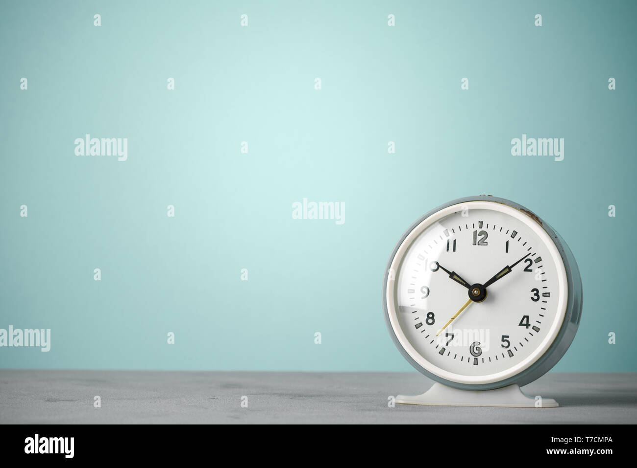 Retro old classic round alarm clock on desk blue vintage color ...