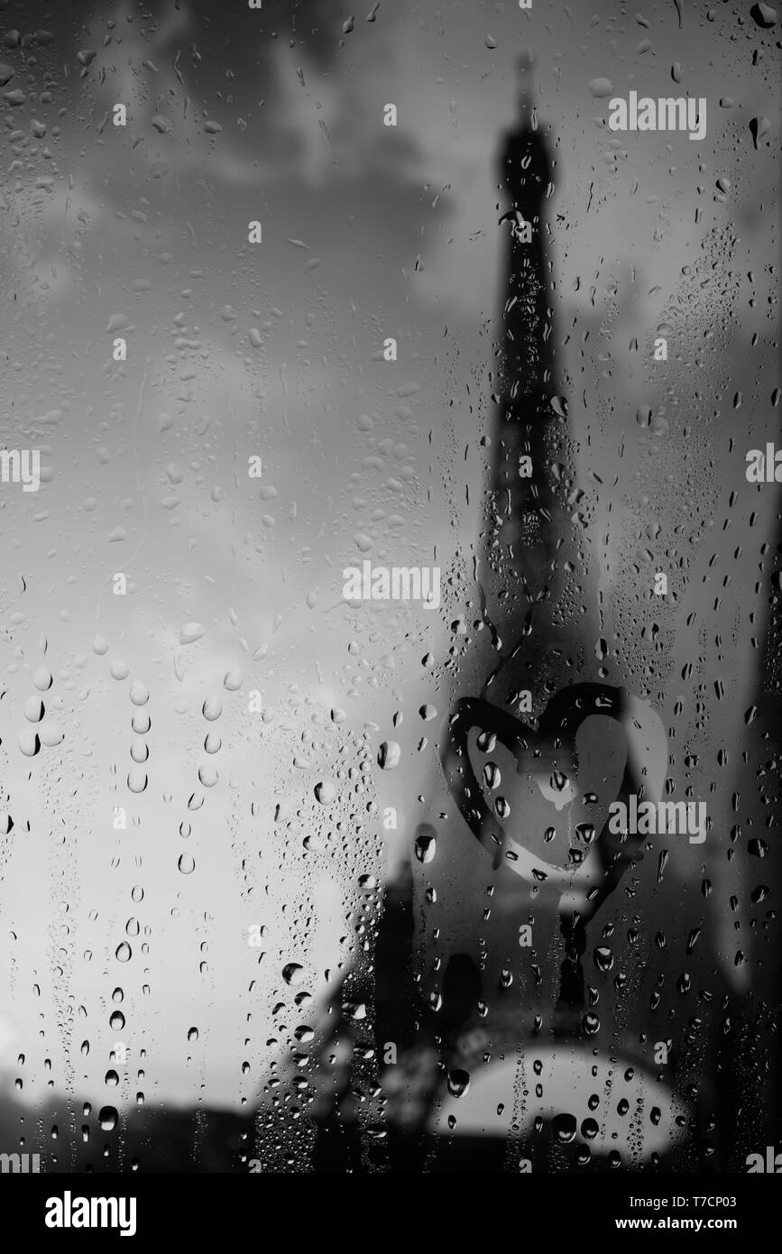 Heart love symbol painted on rainy window with Paris Eiffel Tower on background rainy day Stock Photo