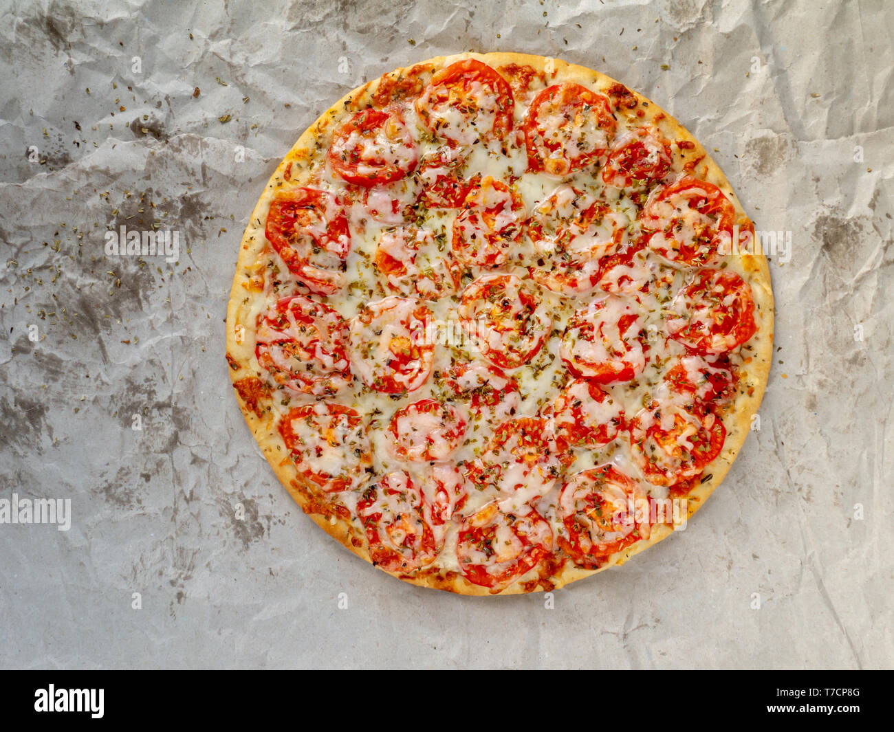 Delicious Pizza Margherita Or Margarita With Mozzarella Cheese Tomatoes And Basil On The Thin Dough Top View On The Crumpled Oiled Paper Background Stock Photo Alamy
