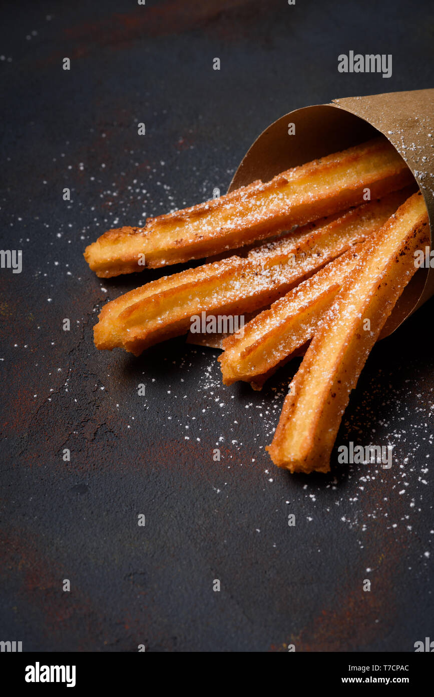 Churro fried sticks in paper bag with sugar powder Stock Photo
