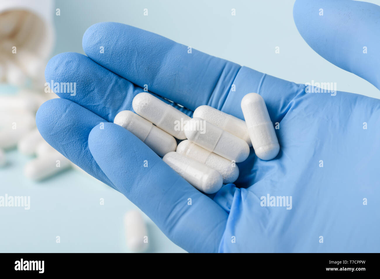 Pills in doctor hand in glove Stock Photo