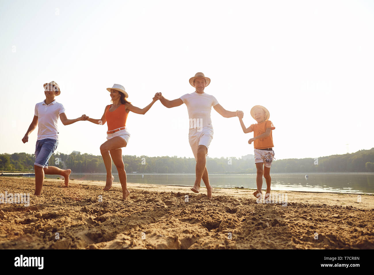 Happy family running on beach hi-res stock photography and images - Alamy