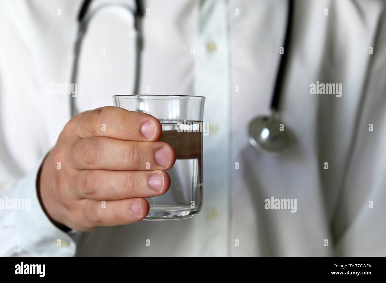 Glass of clean water in hand of doctor. Concept of healthy diet, thirst, water purification, skin care Stock Photo
