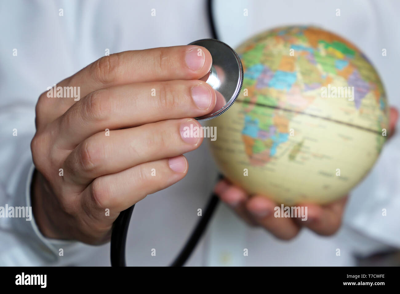 Doctor with stethoscope and a globe in his hands. Health care in Africa, concept of medicine, epidemic control, vaccination Stock Photo
