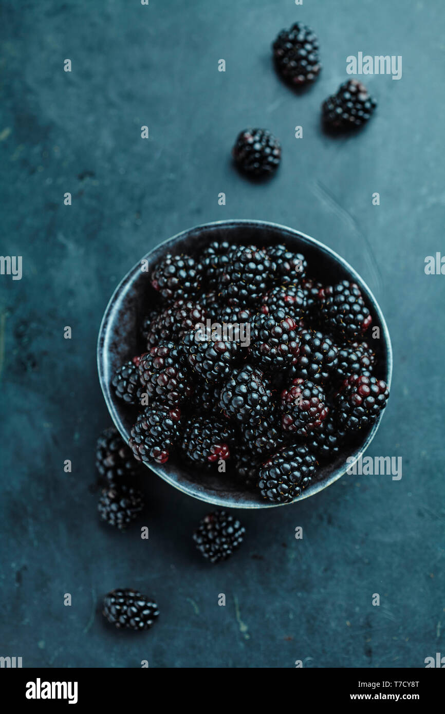 bowl of fresh blackberries on a stone surface Stock Photo