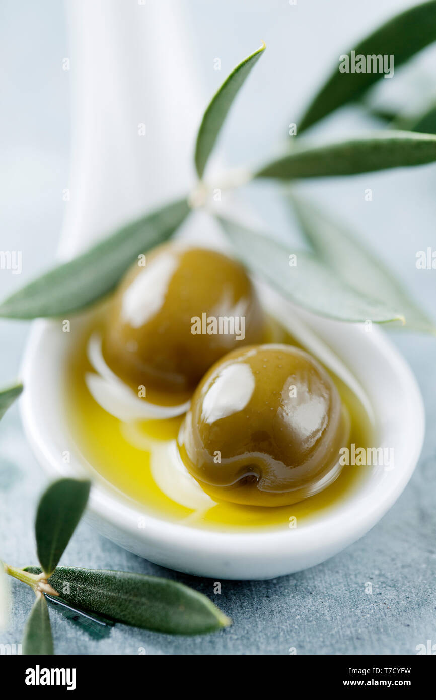 Green olives in oil Stock Photo