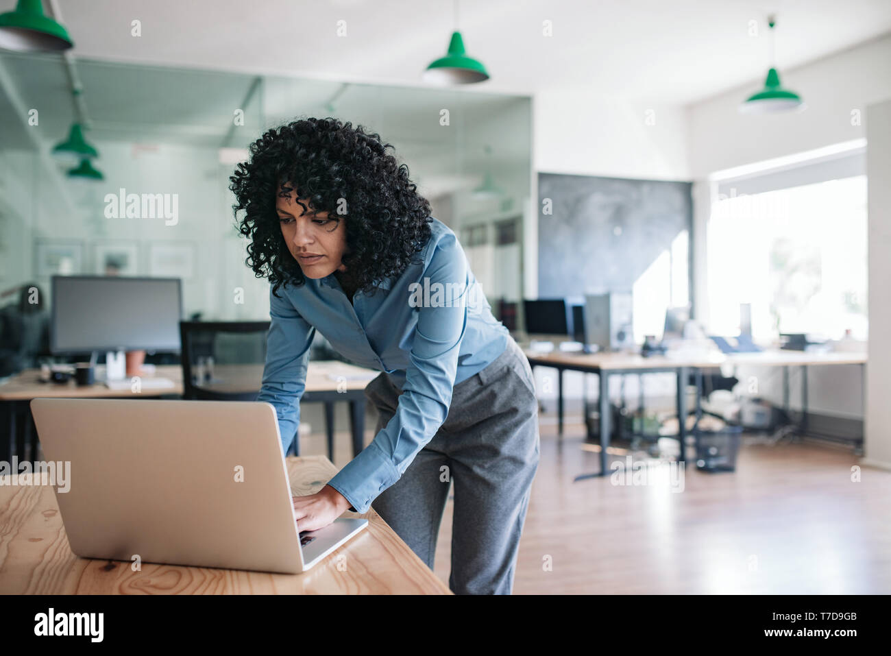 Young woman leaning over desk hi-res stock photography and images - Alamy