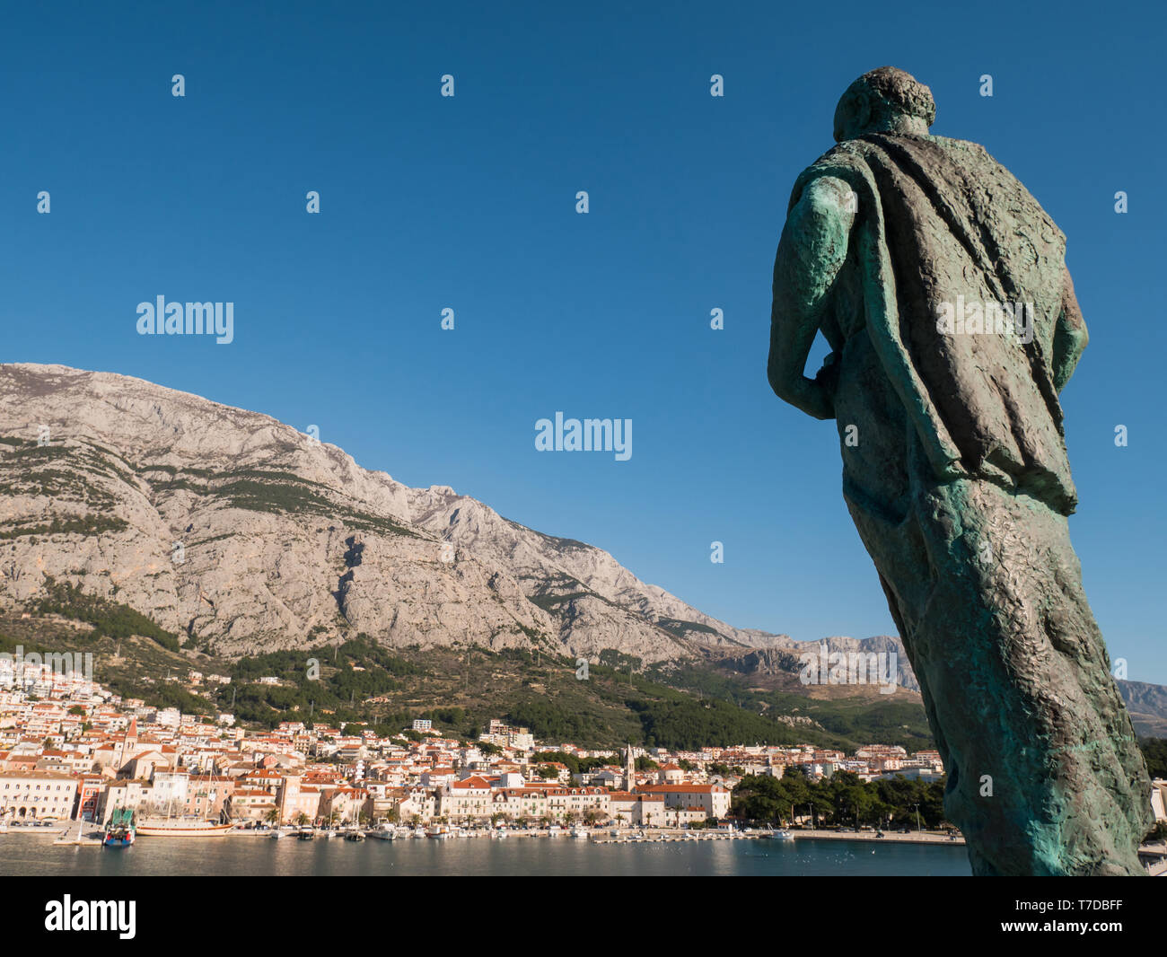 Editoriral - Saint Peter monument in front of city Makarska port on sunny day Stock Photo