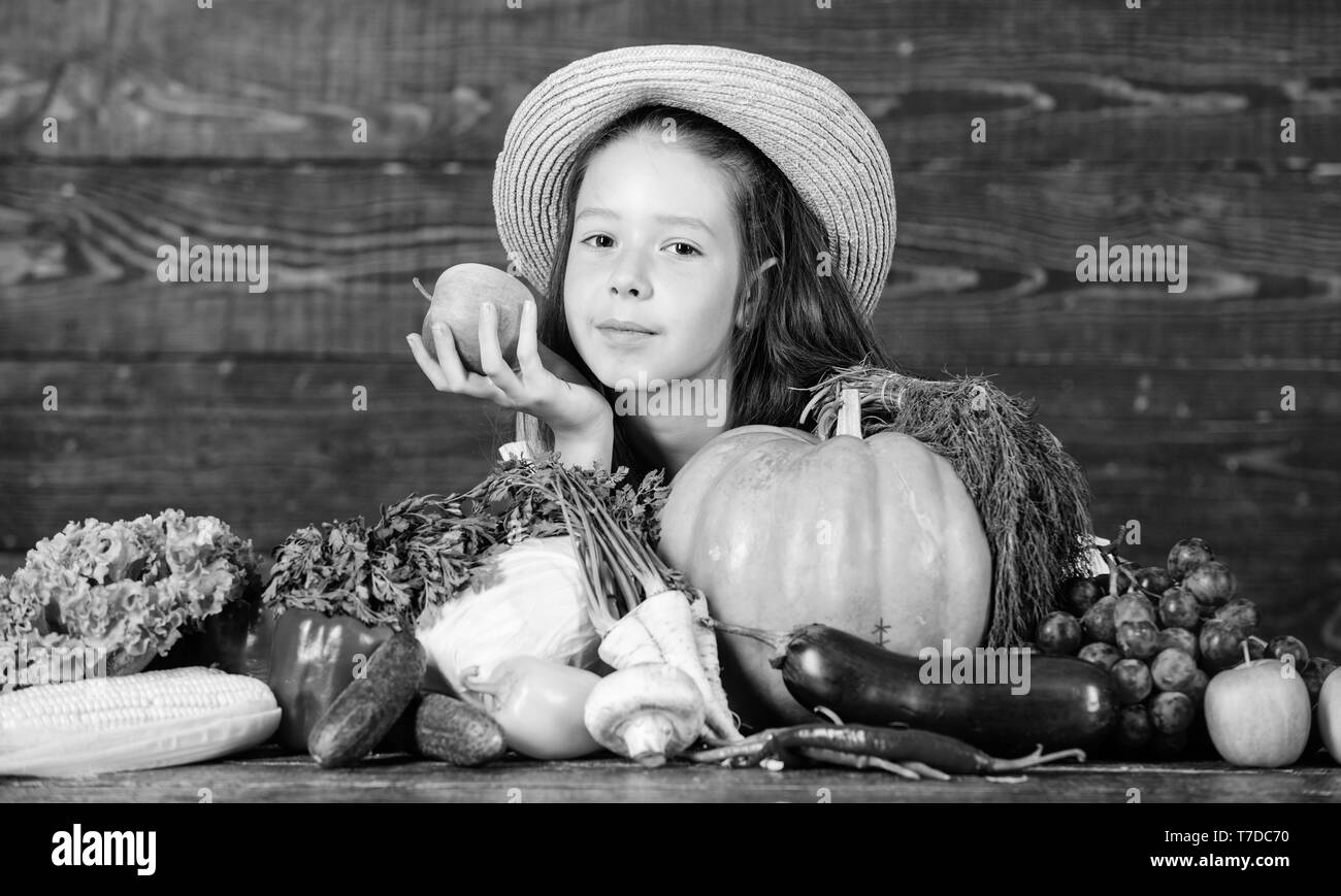 Child celebrate harvesting. Kid farmer with harvest wooden background