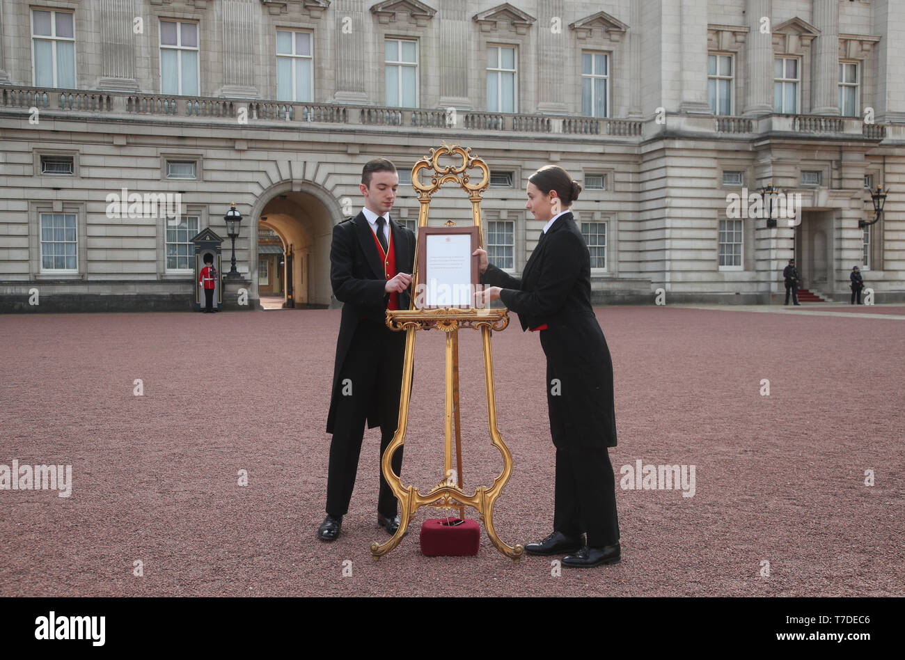 Footmen Stephen Kelly and Sarah Thompson bring out the easel in the forecourt of Buckingham Palace in London to formally announce the birth of a baby boy to the Duke and Duchess of Sussex. Stock Photo