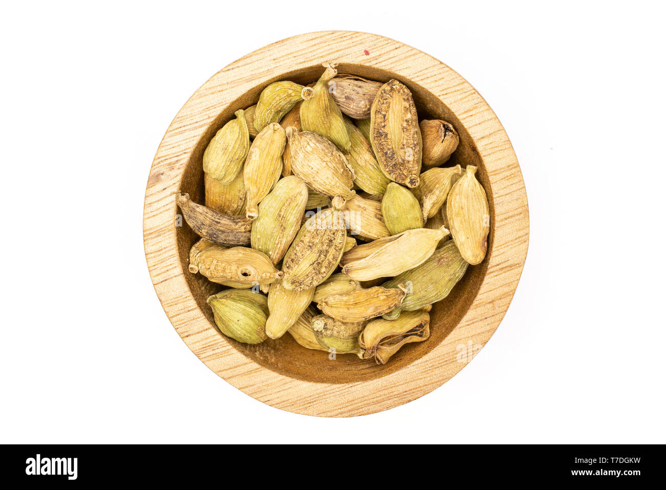 Lot of whole true cardamom pod in a wooden bowl flatlay isolated on white background Stock Photo