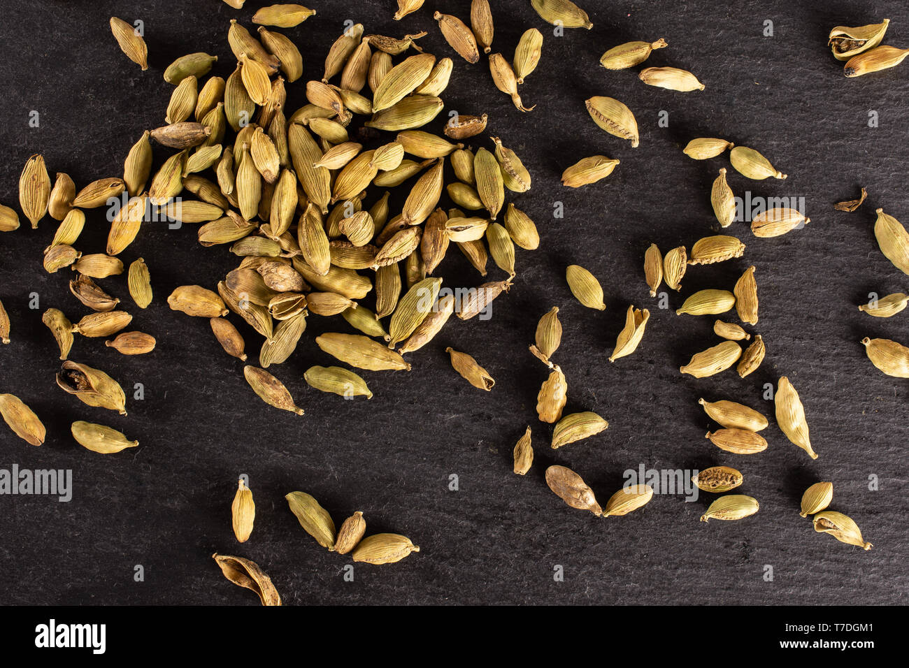 Lot of whole true cardamom pod flatlay on grey stone Stock Photo