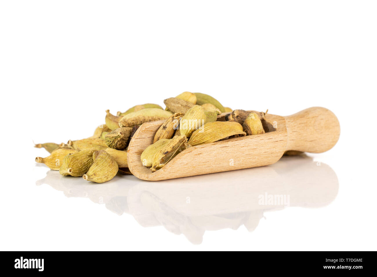 Lot of whole true cardamom pod with wooden scoop isolated on white background Stock Photo