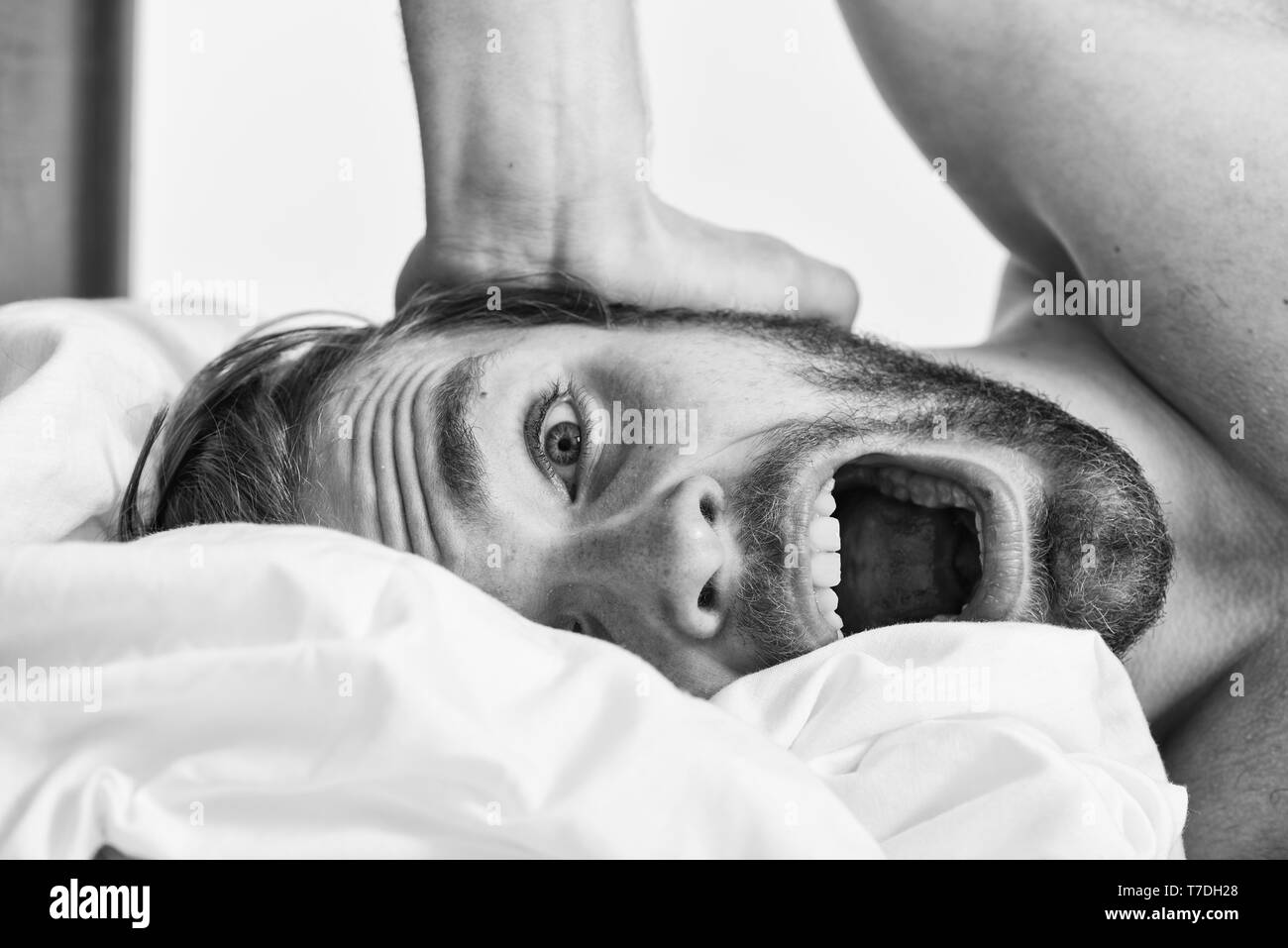 How to get up in morning feeling fresh. Late morning overslept. Morning routine tips to feel good all day. Man handsome guy lay in bed in morning. Tips on how to wake up feeling fresh and energetic. Stock Photo