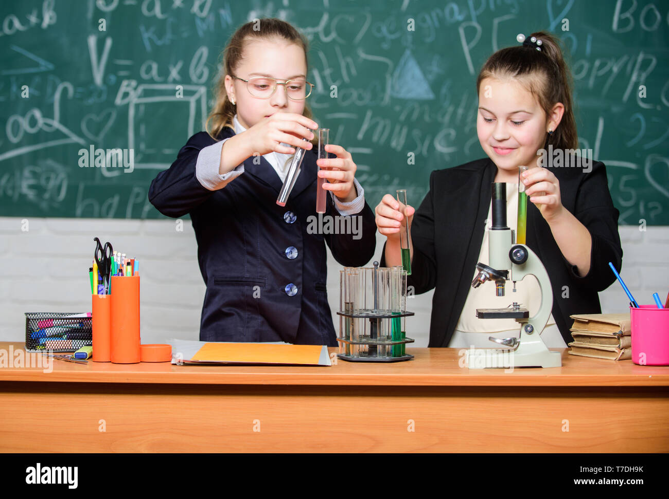 Inspire. Little girls scientist with microscope. Biology lab. Happy
